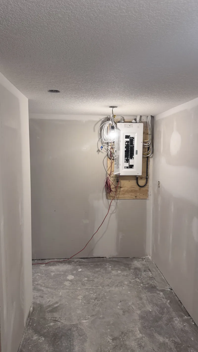 Basement drywall installation and finishing around electrical panel in Calgary home renovation project.